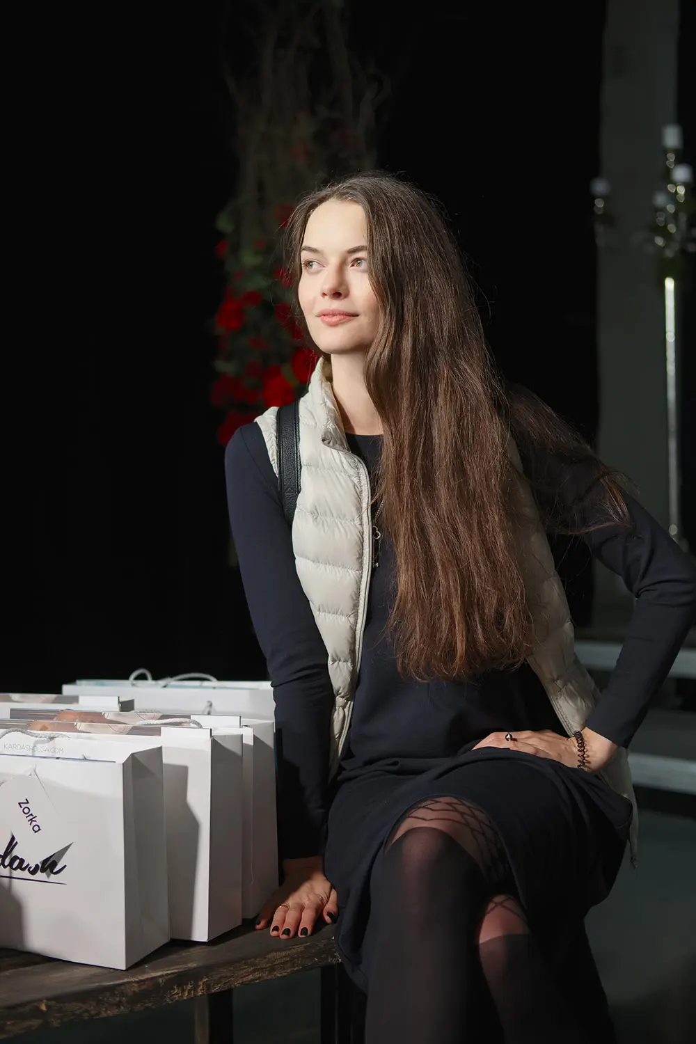 Attractive lady sitting in club on bench near paper bags