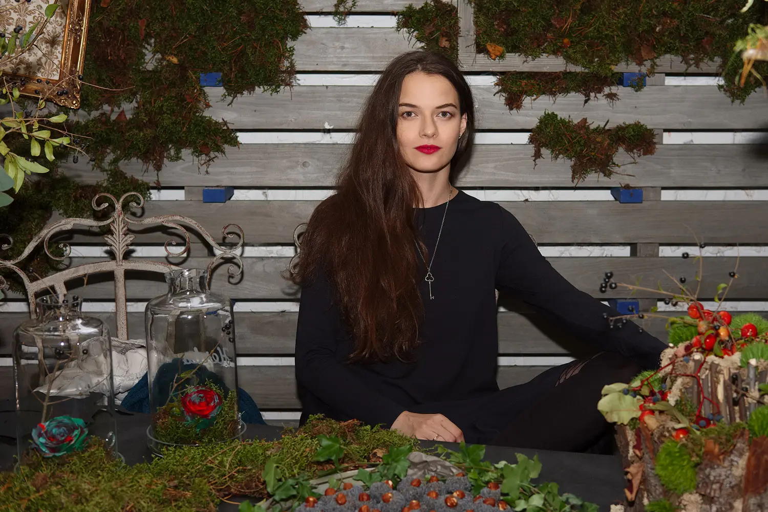 Attractive lady sitting behind herbal table with sweets